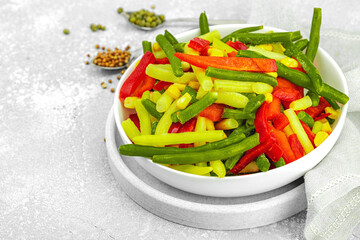 Vibrant frozen vegetable mix with yellow and green beans, red bell peppers, corn. Frosty texture