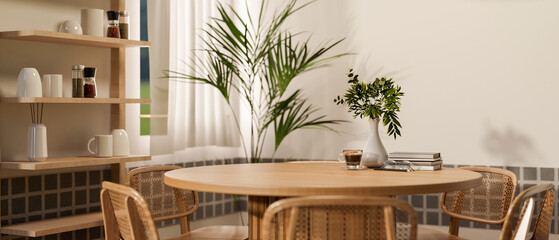 Set of wooden round table and armchairs in dining room or kitchen, with coffee and books placing on.