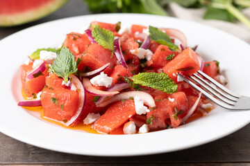 Fresh Watermelon Feta Salad with Mint and Red Onion on wooden table