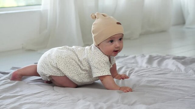 Adorable smiling baby girl learning to crawl on the floor in a bright home interior. child development, first attempts to crawl