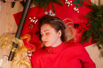 Portrait of smiling young woman lying on New Year's wrapping paper. Christmas and New Year