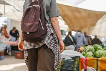Young woman choosing fresh organic vegetables at a local market. Concept of eco lifestyle,...