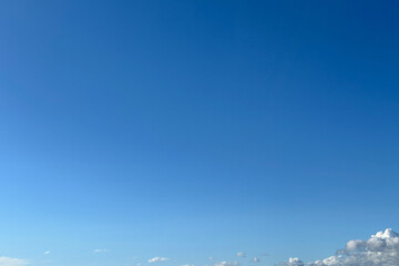 White clouds at the bottom of a bright blue sky gradient, background, screensaver, desktop.