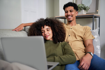 Obraz premium Relaxed Couple Enjoying a Cozy Evening Together at Home While Watching a Laptop