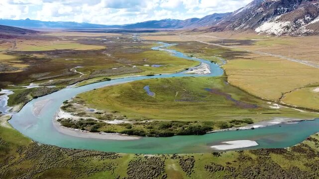 Aerial view of the beautiful autumn scenery of  snow-capped mountains and wetlands at Maoya Grand Grassland along National Highway 318 in Litang County, Western Sichuan, China