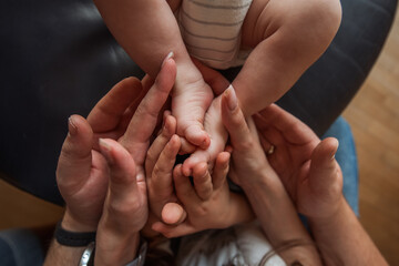 Mother and father lovingly holding the tiny feet of their newborn, showcasing the deep family bonds and tenderness that define their relationship in this intimate moment