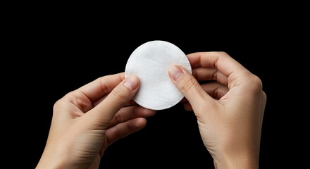 Holding Cotton Pad for Skincare or Makeup Removal on Black Background