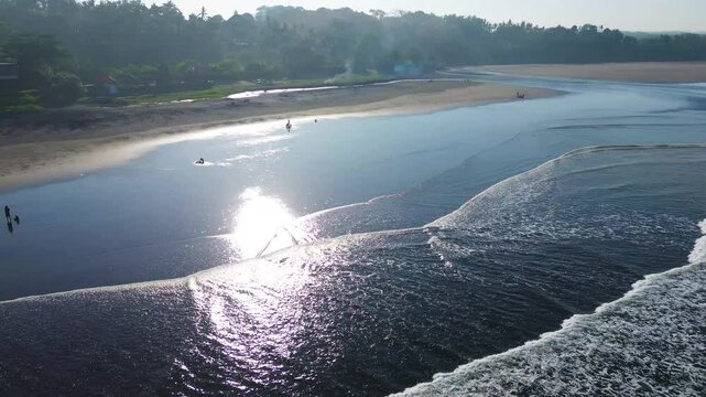 Cinematic drone view of Kelanting Beach in Tabanan, Bali. Shimmering volcanic sand meets crashing waves in this serene yet energetic seaside escape.