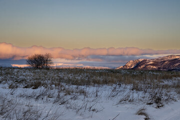 Winter meadow and sunrise clouds, Norway