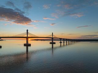 Cua Hoi bridge at sunset over the calm waters of Vinh city in Nghe An, Vietnam showcasing stunning architecture