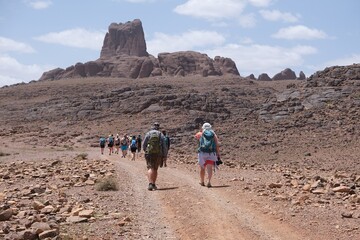 Amazing mountain landscapes of Jebel Saghro with volcanic rocks eroded by wind and time and group of trekking tourists. Atlas, Anti Atlas, Morocco