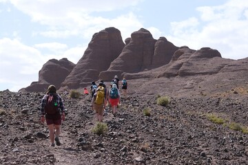 Amazing mountain landscapes of Jebel Saghro with volcanic rocks eroded by wind and time and group of trekking tourists. Atlas, Anti Atlas, Morocco © Iwona