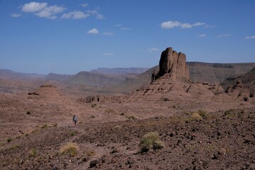 Amazing mountain landscapes of Jebel Saghro with volcanic rocks eroded by wind and time and little silhouette of single man. Atlas, Anti Atlas, Morocco © Iwona