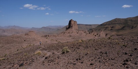 Amazing mountain landscapes of Jebel Saghro with volcanic rocks eroded by wind and time and little silhouette of single man. Atlas, Anti Atlas, Morocco © Iwona