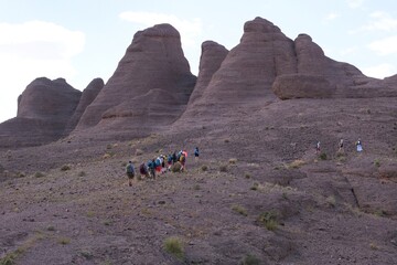 Amazing mountain landscapes of Jebel Saghro with volcanic rocks eroded by wind and time and group of trekking tourists. Atlas, Anti Atlas, Morocco © Iwona