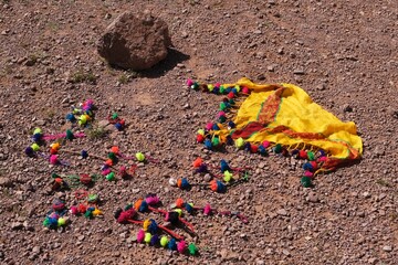 A scarf with colorful pompons, a traditional Berber decoration, lies on the ground. Atlas, Anti...