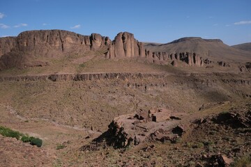 Amazing mountain landscape of Jebel Saghro with volcanic rocks eroded by wind and ruined settlement...