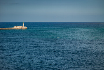 Fototapeta premium Lone Lighthouse on Breakwater in the Mediterranean Sea, Malta