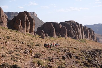 Amazing mountain landscapes of Jebel Saghro with volcanic rocks eroded by wind and time and group of trekking tourists. Atlas, Anti Atlas, Morocco © Iwona