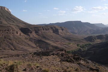 Amazing mountain landscapes of Jebel Saghro with volcanic rocks eroded by wind and time and group of trekking tourists. Atlas, Anti Atlas, Morocco © Iwona