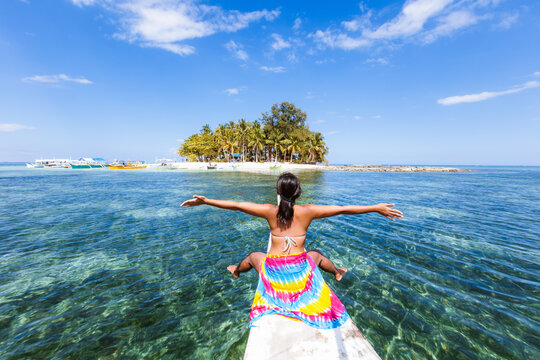 Young woman on boat prow near Guyam island, Siargao, Philippines