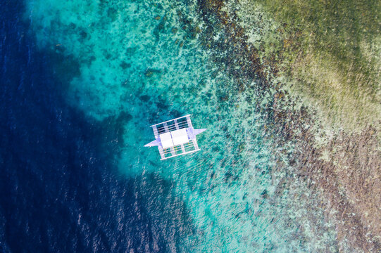 Aerial view of outrigger boat and coral reef, Philippines