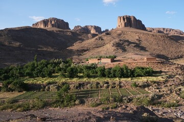 Amazing mountain landscapes of Jebel Saghro with volcanic rocks eroded by wind and time and  settlement with buildings. Atlas, Anti Atlas, Morocco © Iwona