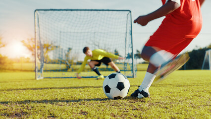 Goal, soccer player and children with ball, kick and athlete with energy, cardio and practice in morning. Sports field, football and kids with sportswear for game, growth and development with fitness