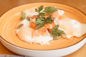 Fried eggs with tomato, mushroom, and parsley served on a plate for a healthy breakfast. Natural and fresh food concept.