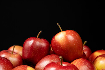 Group of fresh organic red whole apples on a black background. Space for text