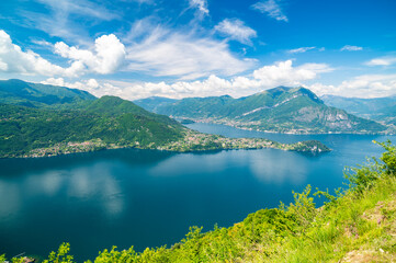 Panorama of Lake Como photographed at Alpe Mezzedo in Esino Lario, showing Bellagio, Balbianello, the Lecco and Como shores of the lake and the mountains above.
