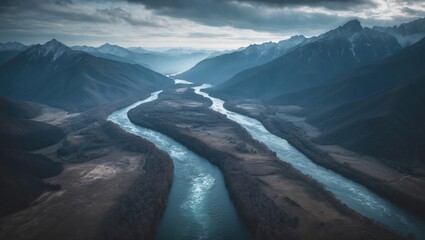 Rivers flowing through mountains from above, with valleys and peaks in the background, showing a remote wilderness landscape.