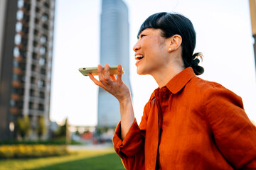 Businesswoman engaged in a conversation while enjoying the sunny cityscape in a modern urban area