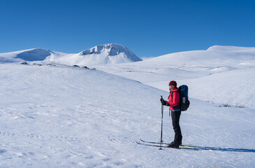 Woman enjoying a beautiful day cross-country skiing the Sylarna mountainrange. Sweden.
