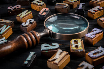 Vintage Letters and Magnifying Glass on Black Wooden Background for Research or Analysis Concept