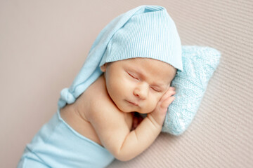 Studio Photo Of A Newborn Baby Sleeping In Turquoise Hat And Pants