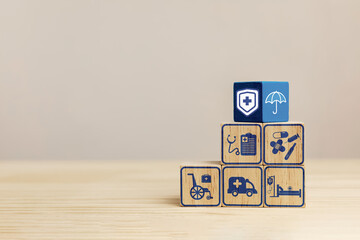 Wooden blocks with medical service icons and umbrella representing protection. Health insurance planning Concept, financial risk protection for medical expenses, and assisting in managing health risks