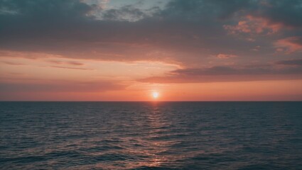 Obraz premium Sunset over the ocean with a colorful sky and calm waters. Nature and seascape, evening scene. The scene of tranquility and beauty at dusk.
