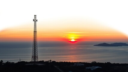 Sunset Serenity: Coastal Tranquility Beneath Towering Cell Tower