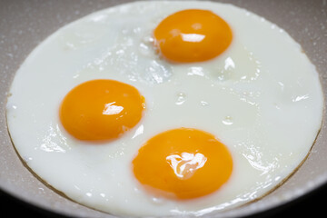 Drei Spiegeleier in Bratpfanne von oben fotografiert