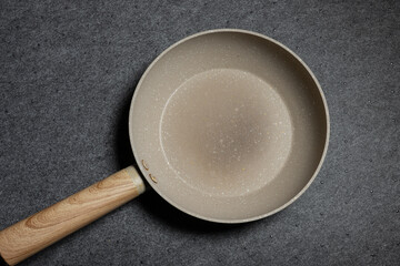 Bratpfanne mit Holzgriff auf dunklem Untergrund