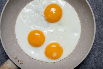 Drei Spiegeleier in Bratpfanne von oben fotografiert