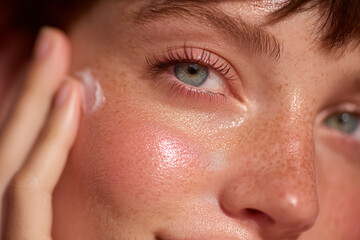 Close-up of glowing, dewy skin as a woman applies moisturizer—perfect for skincare, beauty, wellness, cosmetics, or clean beauty campaigns