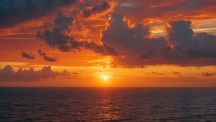 Obraz premium Sunset over the ocean with vibrant orange and red clouds. Beautiful nature scene, peaceful and calming.