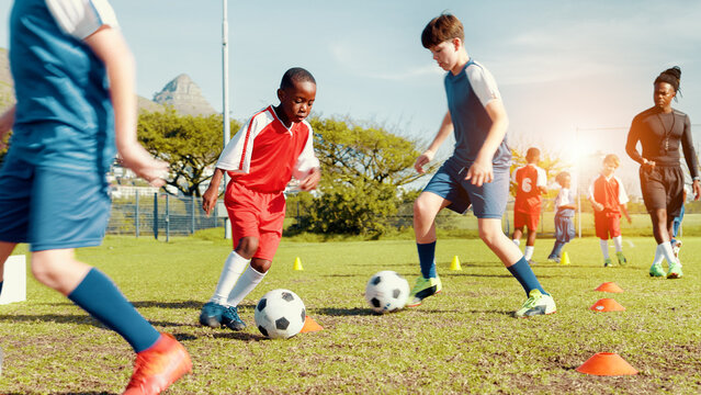 Sports field, soccer player and children with ball, kick and athlete with energy for practice in morning. Playing, football and kids with sportswear for game, growth and development with fitness
