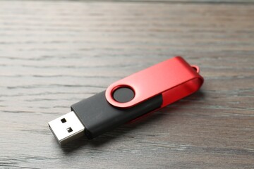 One flash drive on wooden background, closeup. Space for text