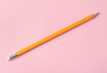 One sharp graphite pencil on pink background, top view