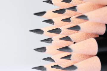 Many sharp graphite pencil on white background, closeup