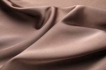 Fototapeta premium Crumpled light brown silk fabric as background, closeup