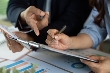 Analyzing Financial Reports. Professionals discussing strategy over charts and documents.